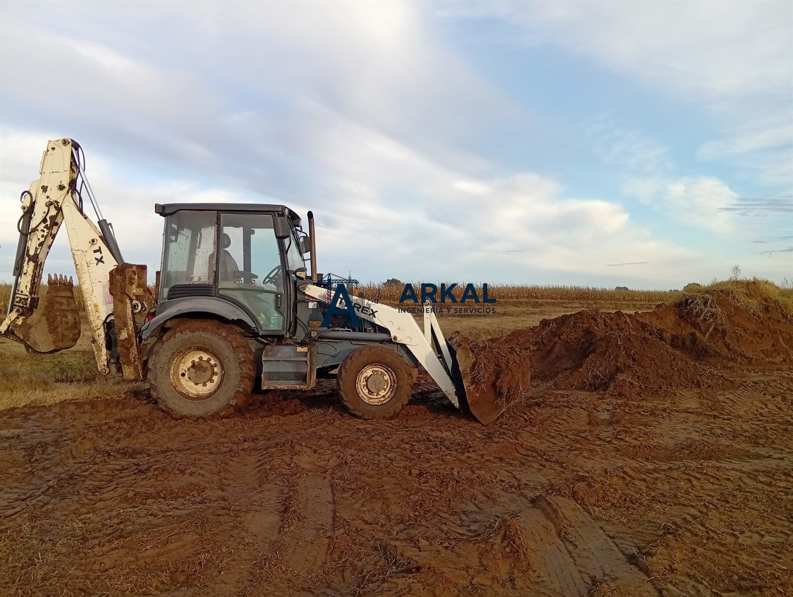 Retroexcavadora cargando tierra para el terraplén del acceso
